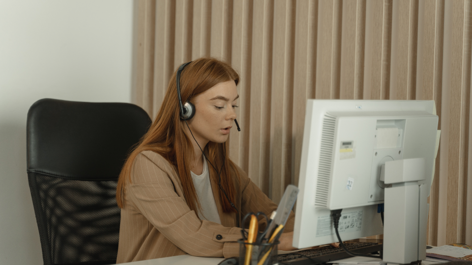 woman headset infront of computer